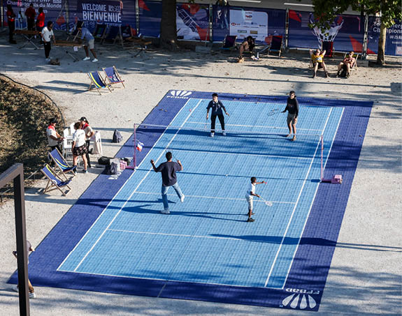 A group of people playing tennis on a blue court. AI generated content