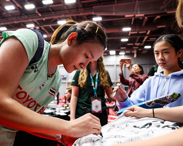A woman signing autographs for fans at a convention. AI generated content