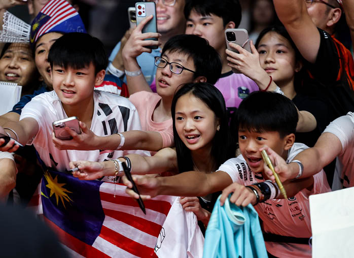 A group of people are gathered around a young boy holding a cell phone. AI generated content