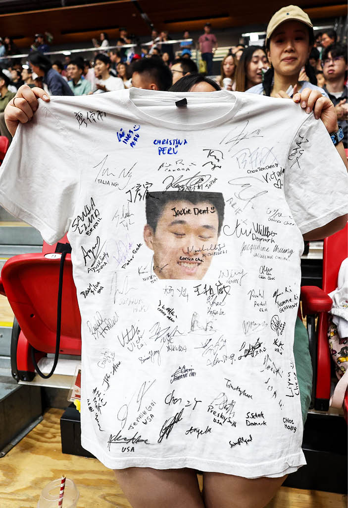 A woman wearing a white shirt with a picture of a man on it is holding the shirt up for a young girl to see. AI generated content