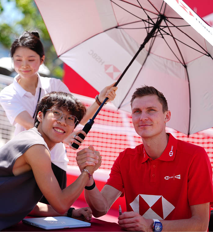 A man and a woman are sitting under an umbrella. The woman is holding an umbrella over the man. AI generated content