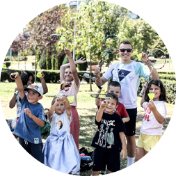 A group of children and adults are standing in a park, holding frisbees. AI generated content