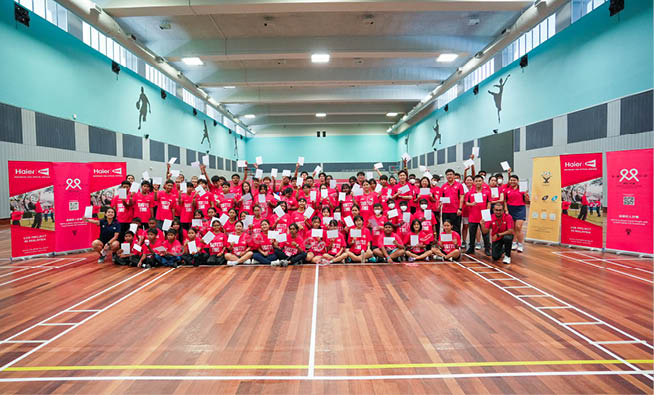 A large group of people wearing red shirts are standing in a gymnasium. AI generated content
