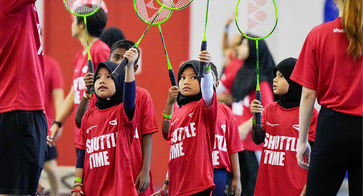 A group of children wearing red shirts are holding tennis rackets. AI generated content