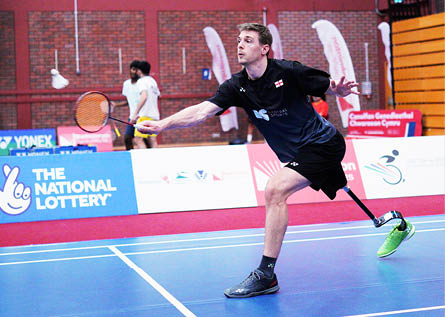 A man in a black shirt and black shorts is playing tennis on a court. AI generated content