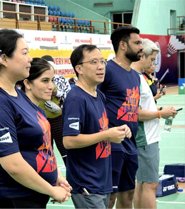 A group of people wearing blue shirts and shorts are standing on a tennis court. AI generated content