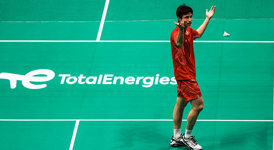 A man in a red shirt and white shorts is holding a tennis racket on a tennis court. AI generated content